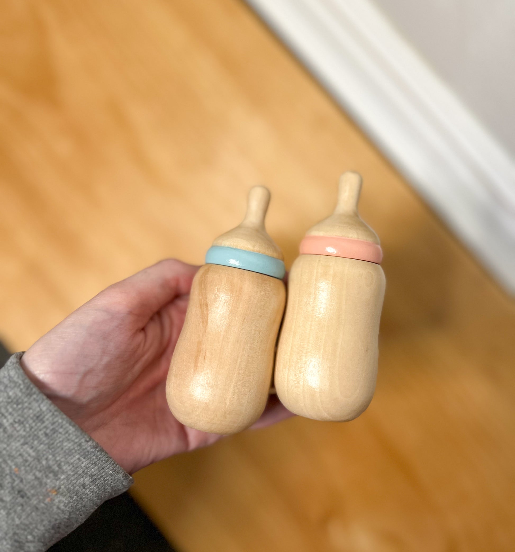 two wooden baby doll bottles