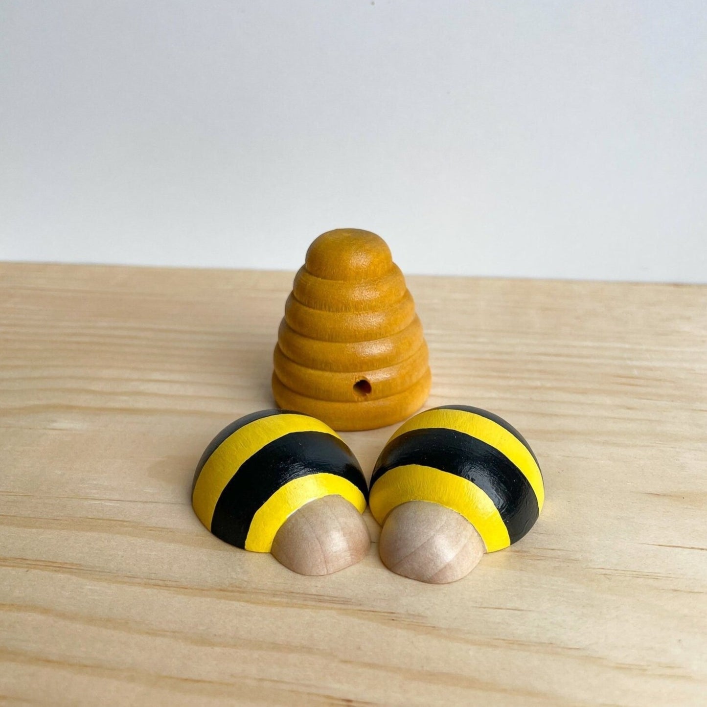 2 wooden bees with beehive